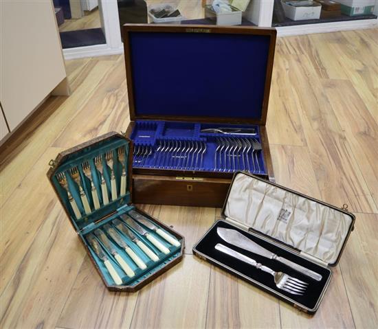A part canteen of plated cutlery, oak cased; a pair of plated fish servers and a set of six plated fish knives and forks (both cased)